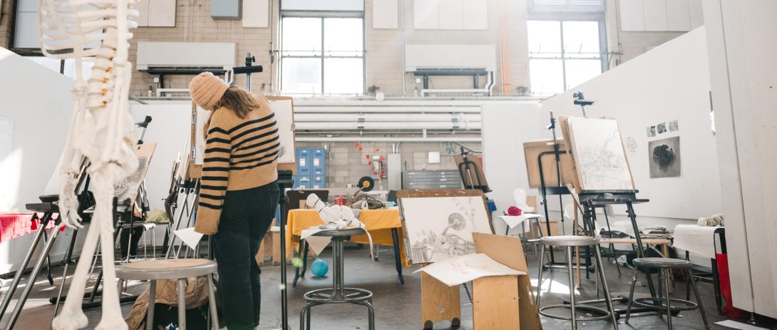 Student stands in an art studio.